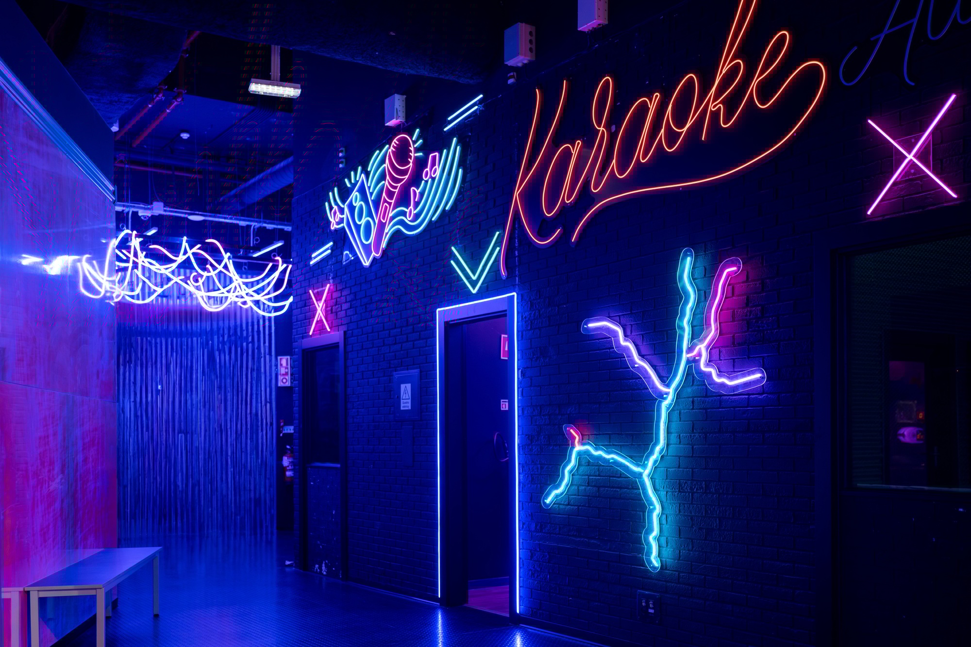 Glowing neon sign with word Karaoke and microphone in arcade